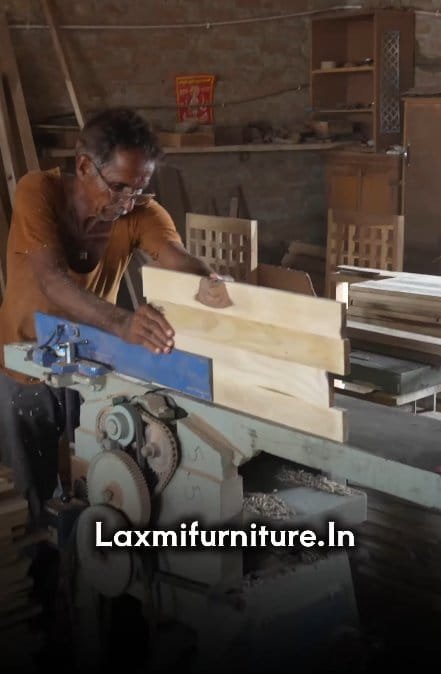 Laxmi Furniture artisan planing Sheesham wood planks on a machine in the factory